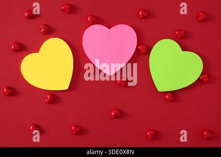 Heart shape sticky notes laying on rose petals Stock Photo