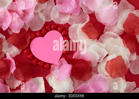 Heart shape sticky notes laying on rose petals Stock Photo