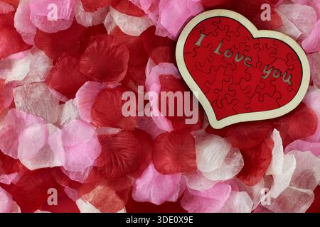 "I love you" wooden puzzle, heart shaped with rose petals Stock Photo