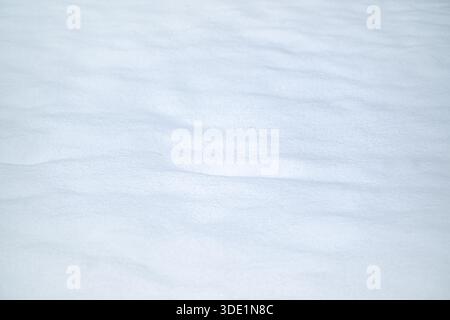 Snow surface texture with gentle drifts in waves, full frame background for the cold winter season or holidays like Christmas or new year, copy space, Stock Photo