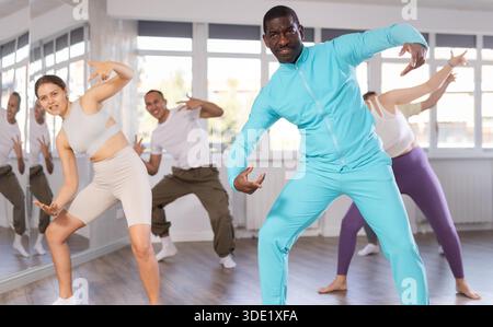 Middle-aged African-American man practicing breakdance in training hall Stock Photo