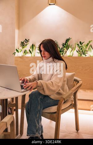 Woman working on laptop remote in modern cafe Stock Photo