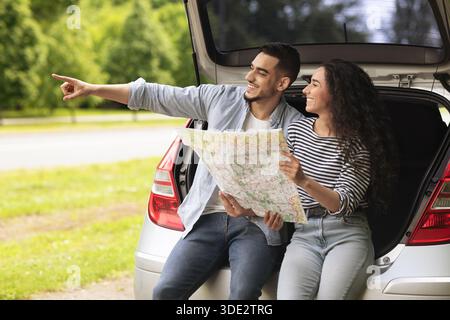 Excited guy traveller showing his girlfriend something aside, copy space Stock Photo