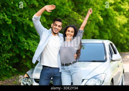 Emotional multiracial couple standing by nice auto Stock Photo
