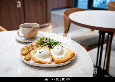 Eggs Benedict breakfast with cup of coffee in a restaurant. Stock Photo