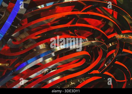 Wavy copper texture, smooth, shiny, brushed metallic surface. Abstract background with red and metallic curved ribbons creating dynamic visual rhythm. Stock Photo