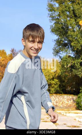 Cheerful teenager walking in the autumn park Stock Photo