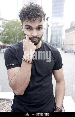 Cheeky man thoughtfully pouting mouth in surprised reconsideration in inner city of Frankfurt am Main in Germany, Moroccan ethnicity, North African et Stock Photo