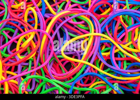 a dense, chaotic tangle of colorful intertwined elastic rubber bands in vibrant shades Stock Photo