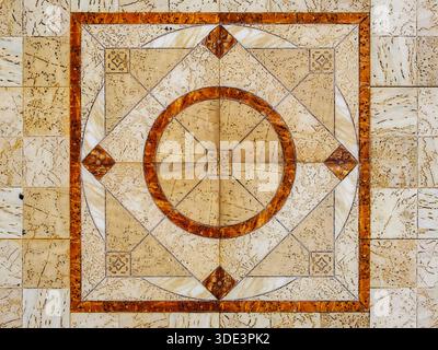 a marble tile floor featuring a central circular pattern with a four-pointed star design. The pattern is symmetrical and intricate, showcasing geometr Stock Photo
