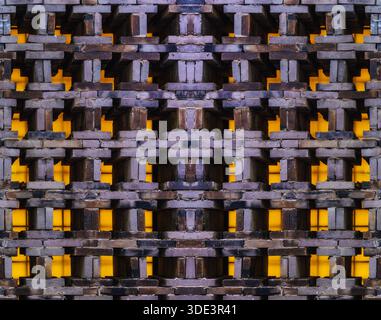 a textured brick wall featuring a complex, three-dimensional pattern. The bricks are arranged in a staggered, interlocking design, creating a series o Stock Photo
