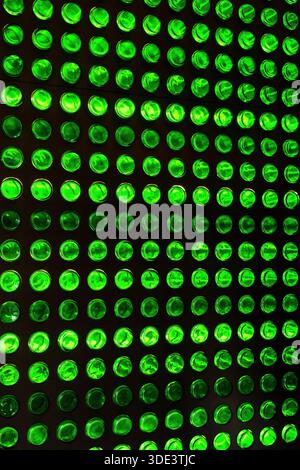 a wall made of beer bottles illuminated from behind Stock Photo