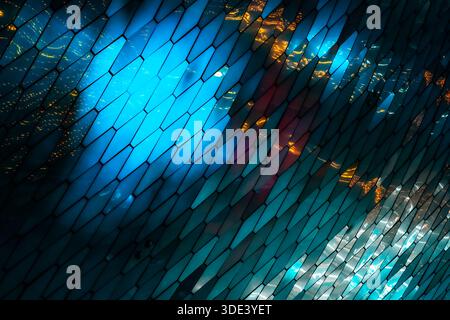 abstract, geometric wall made of hexagonal, glass-like tiles. The tiles reflect colorful lights creating a vibrant, shimmering effect. The overall tex Stock Photo