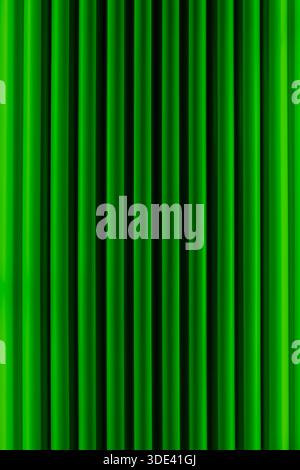 vibrant green velvet curtains with vertical pleats, creating a rich, textured background. The curtains are evenly spaced, with a slight sheen that hig Stock Photo