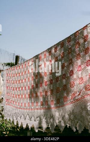 Knitted tablecloth hanging to dry outdoors Stock Photo