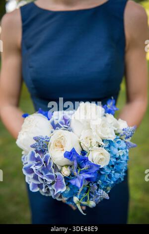 Bridesmaid in Navy Holding White and Blue Floral Bouquet Stock Photo - Alamy