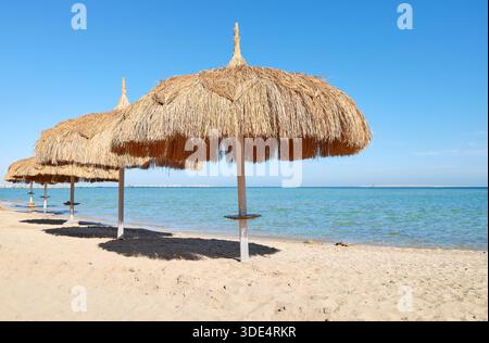 Straw umbrellas on the beach in Hurghada, Egypt. Stock Photo