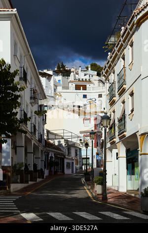 Dark clouds gather over the sunny town of Cómpeta as a winter storm approaches Stock Photo