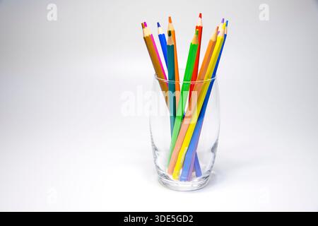 Bright, colorful pencils neatly arranged in a glass, perfect for creative, educational, and office visuals with a playful, organized look. Stock Photo