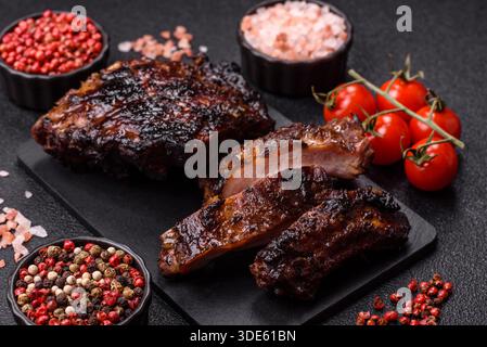 Grilled or barbecued pork or beef ribs, meat with red sauce, ready for the dinner table. Grilled ribs as a food background for your design Stock Photo