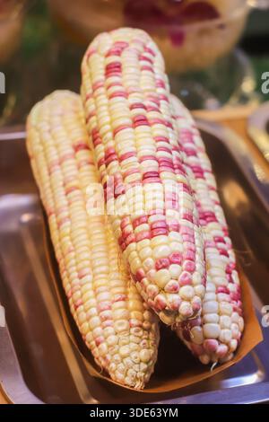 Thai waxy corn with purple and white kernels, showcasing organic superfood nutrition, traditional agriculture, Southeast Asian street food heritage. Stock Photo