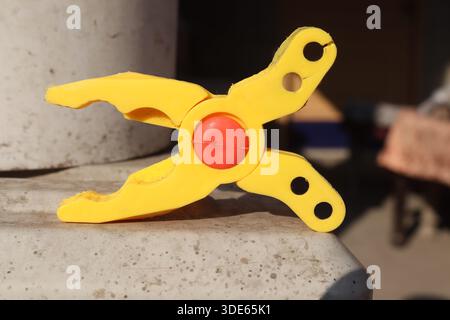 Broken yellow pliers open face toy with red pivot point detail damaged tool macro close up industrial hardware object repair concept isolated Stock Photo