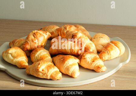 Freshly baked croissants on a white plate on a white background Stock Photo
