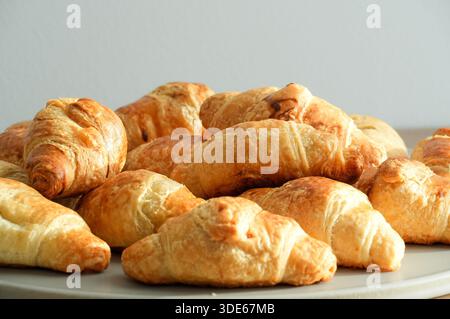 Freshly baked croissants on a white plate on a white background Stock Photo