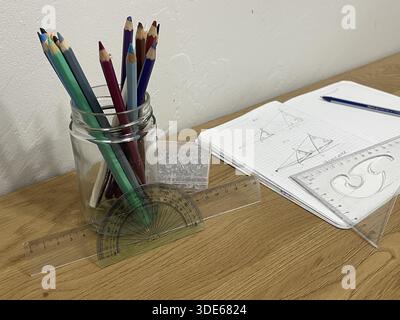 School supplies on a student's desk. Notebooks with homework and geometry tools. Stock Photo