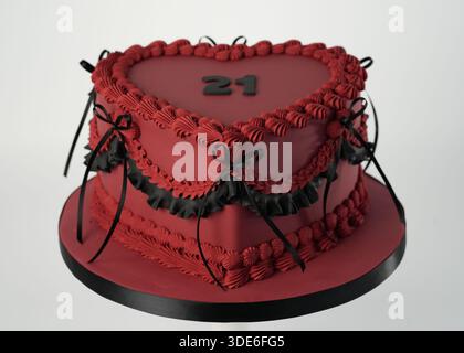 Heart-shaped burgundy birthday cake decorated in Lambeth piping style with black ribbon bows and the number 21, photographed in a studio setting on a Stock Photo