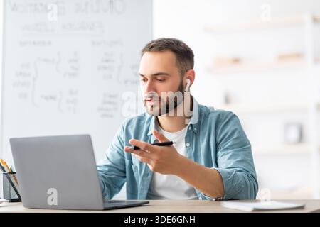 Learning English online. Focused male teacher giving foreign language lesson on web using laptop Stock Photo