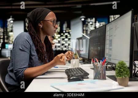 Developer utilizing AI LLM assistant on computer to optimize performance and forecast issues. IT expert in tech company office training neural network deep learning models to perform automatic updates Stock Photo