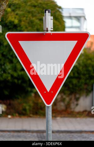 Red and white inverted triangle yield sign indicating traffic instructions Stock Photo