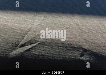 Grey textile surface highlighting abstract shadows and interwoven texture Stock Photo