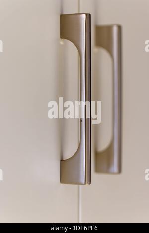 Brushed metal cabinet handles providing a contemporary detail to storage furniture Stock Photo