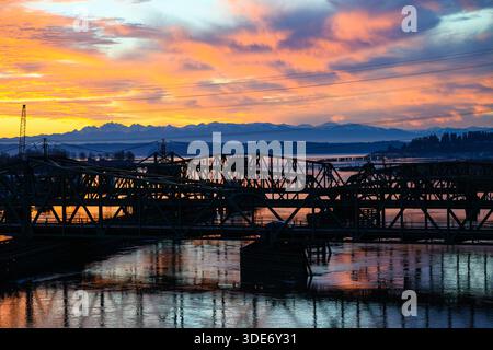 Colorful sunset over Olympic Mountains and road and rail bridges over Steamboat Slough Stock Photo