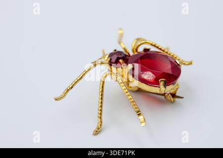 Antique Art Deco Czech Glass Beetle Brooch Pin in Red and Gold – Vintage Insect Jewelry on White Background Stock Photo