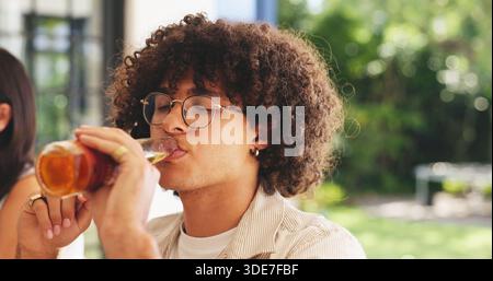 Man, drinking beer or relax in home with friends for summer holiday, weekend hangout or social gathering. Bokeh, person or alcohol beverage with glass Stock Photo
