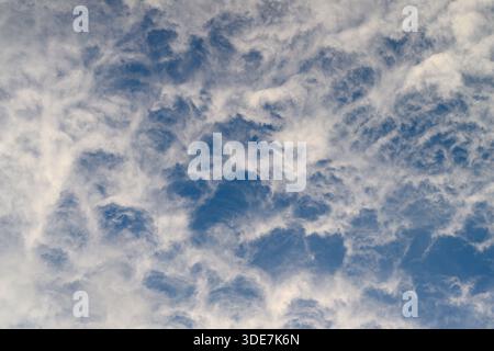 Stunning and mesmerizing cloud formations are creating intricate and beautiful patterns against a bright blue sky Stock Photo