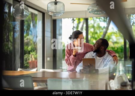 Multicultural couple working remotely, planning finances and investments online. Digital lifestyle Stock Photo