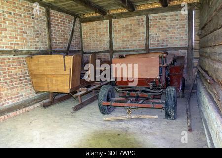 Rustic barn interior with vintage wagon and old wooden horse-drawn sleigh Stock Photo