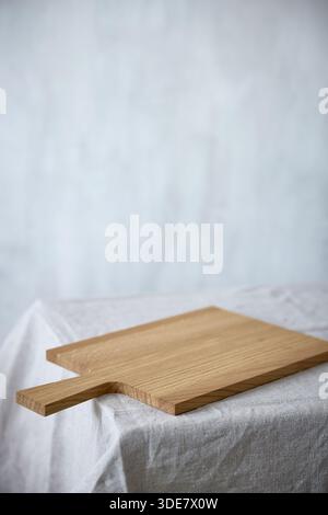 empty new wooden cutting board on beige table background Stock Photo