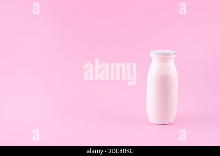 Natural liquid yogurt with probiotics in small plastic bottles on pink background. Healthy, balanced diet food, healthy breakfast, dairy products. Sel Stock Photo