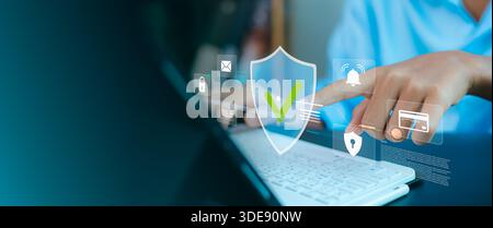 Close up of hand touching virtual security shield icon on laptop. Concept of cybersecurity, data privacy, network protection, firewall and secure onli Stock Photo