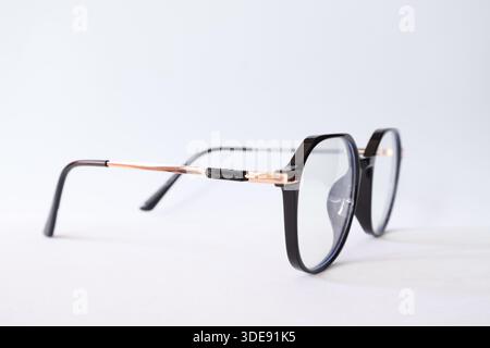 Modern black frame spectacles with rose gold details, isolated on a white background. Minimalist fashion and vision concept. Stock Photo