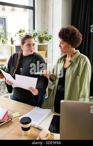 Two female managers discuss plans and share ideas in a contemporary office setting. Stock Photo