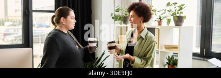 Two female managers share ideas and enjoy coffee in a vibrant office filled with greenery, banner Stock Photo