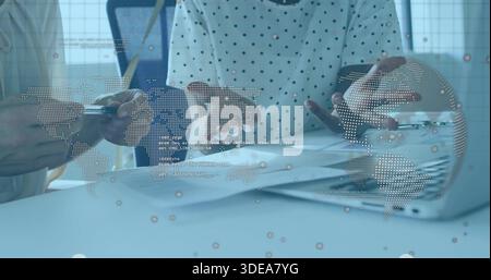 Reviewing two colleagues in light blazer and dotted top studying charts at office with data overlay Stock Photo