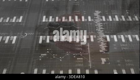 Displaying digital dashboard on office glass, showing charts and faint reflection in dark blazer Stock Photo