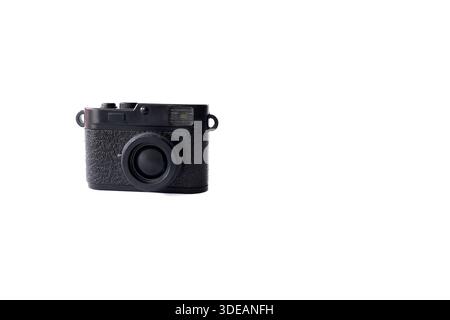 Small black retro camera toy isolated on a plain white surface with copy space. Minimalist photography concept. Stock Photo